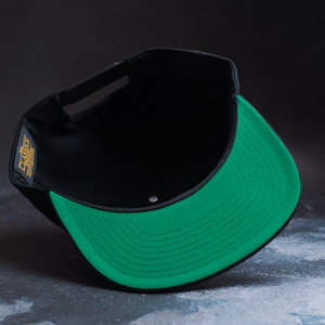 Black snapback hat with embroidered Fa Ram logo patch on the front. Bottom of hat view.